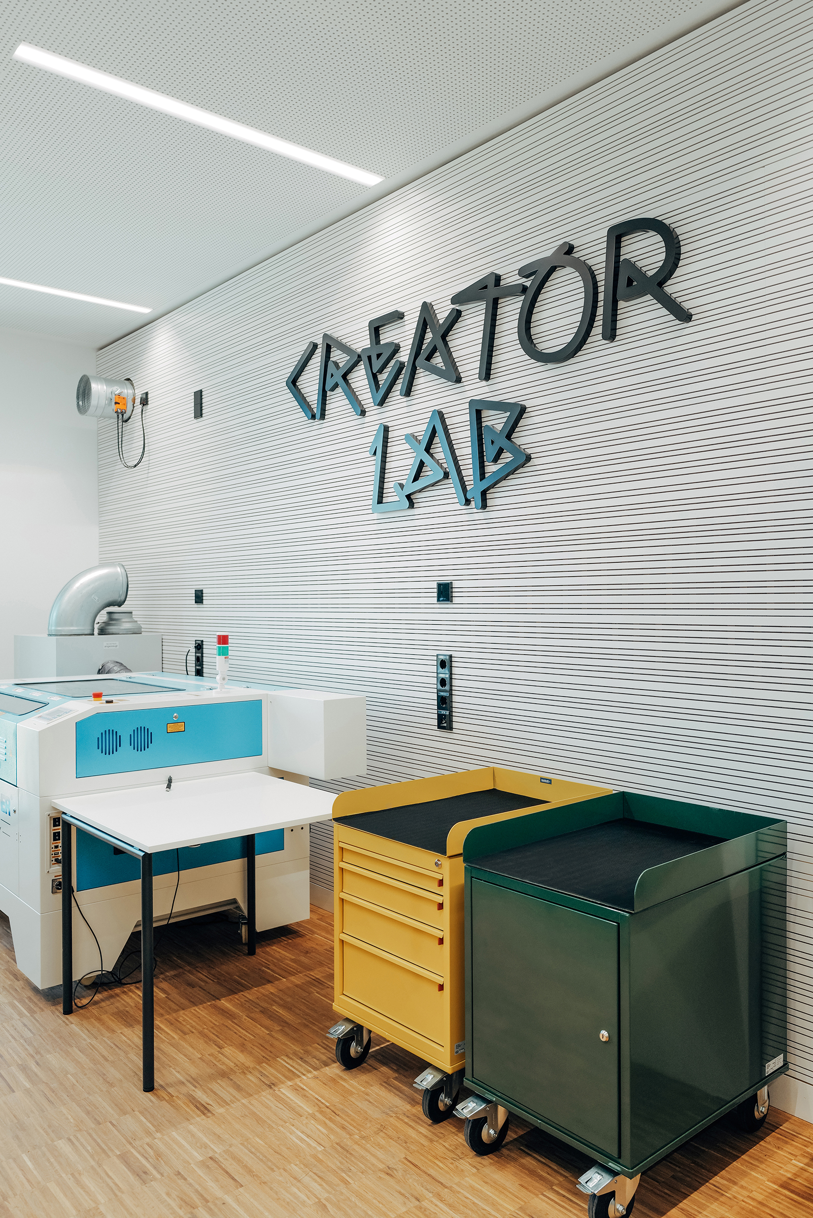Creator Lab mit farbigen mobilen Werkstattmöbeln und individuell gestalteter Beschriftung