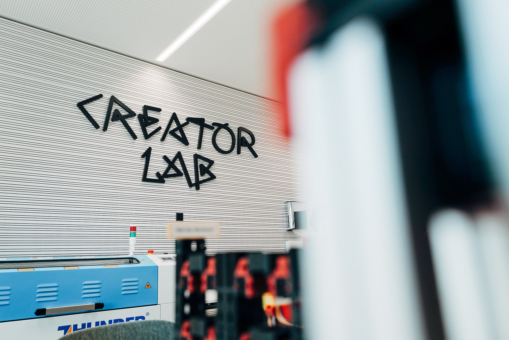 Detailansicht des Creator Lab mit schwarzer Typografie und technischer Laborausstattung